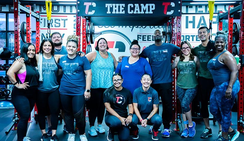 A large group of members and coaches posing together after a class.